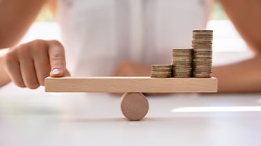 Balancing Director's salary on a wooden seesaw